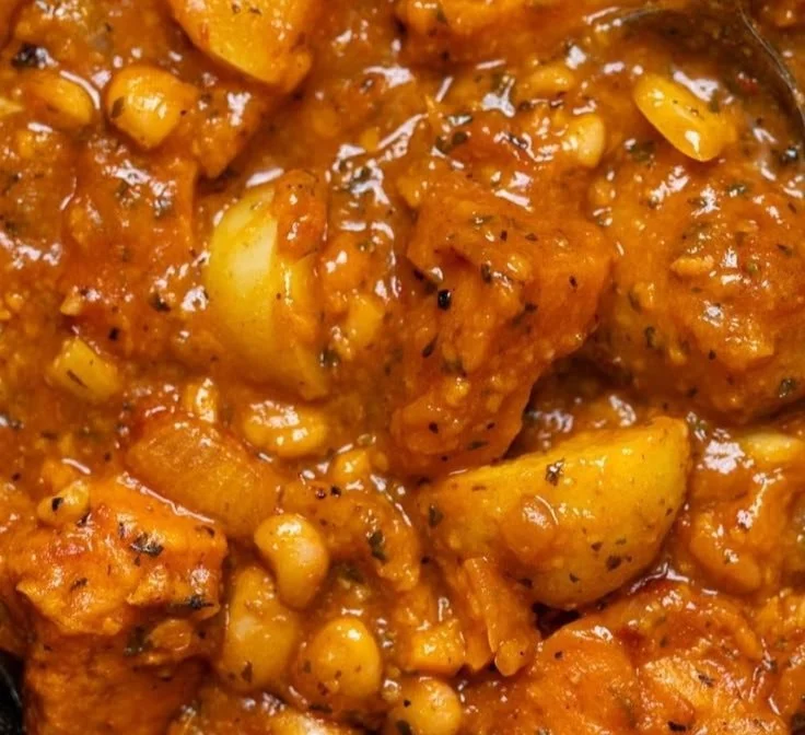 A bowl of robust vegan sweet potato stew filled with vegetables and herbs