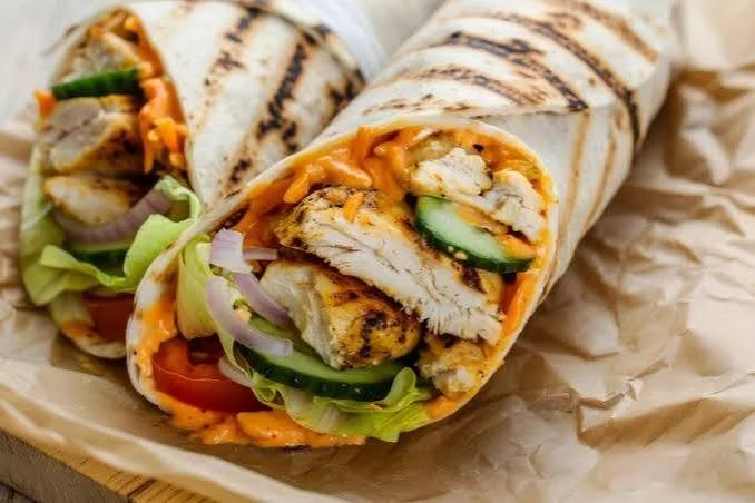Sweet Chili Chicken Wraps with fresh vegetables and sauce on a plate