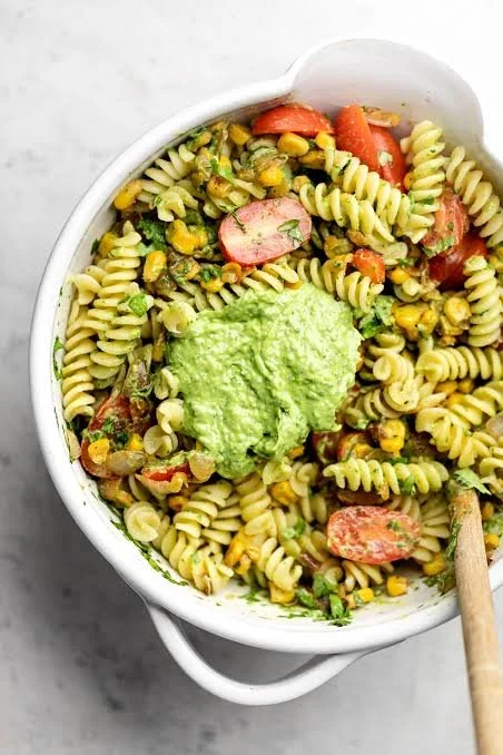 Vegan avocado pasta salad with fresh ingredients on a plate