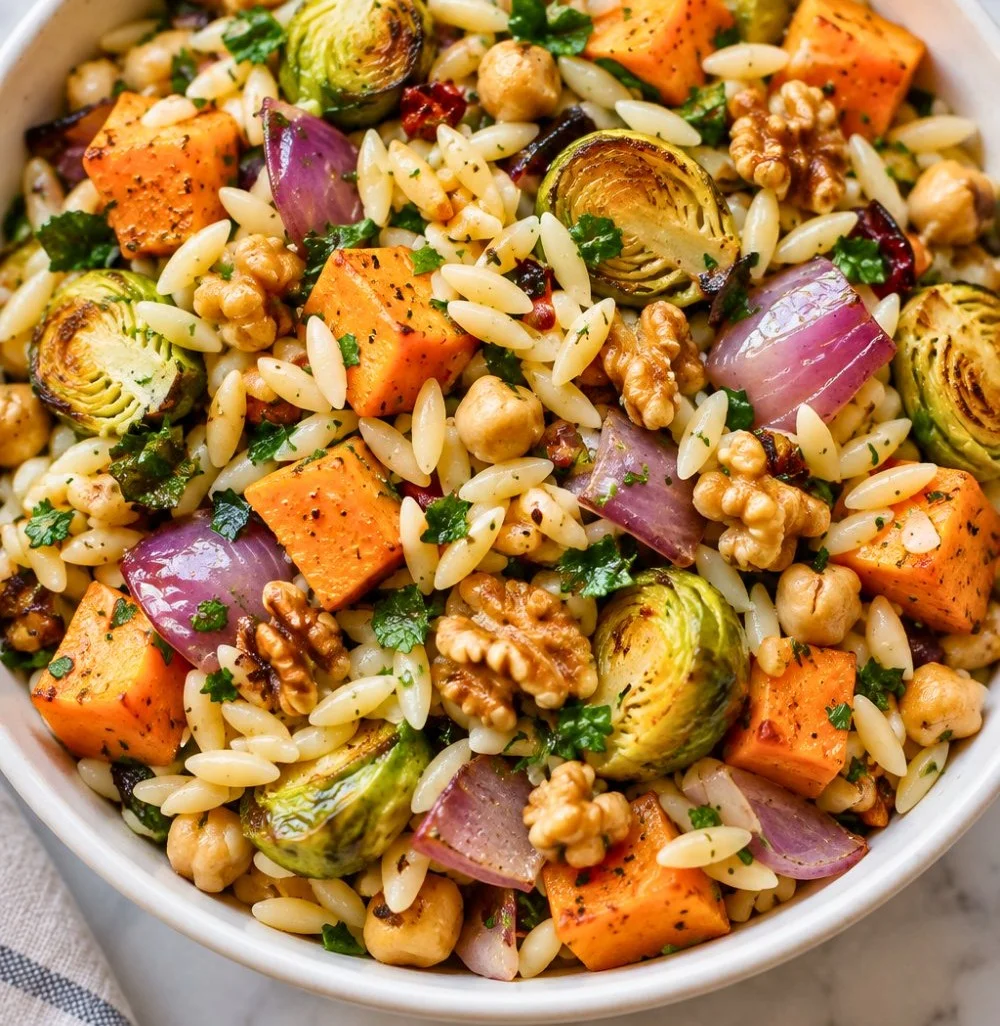 Colorful vegan orzo salad with roasted vegetables and chickpeas in a bowl
