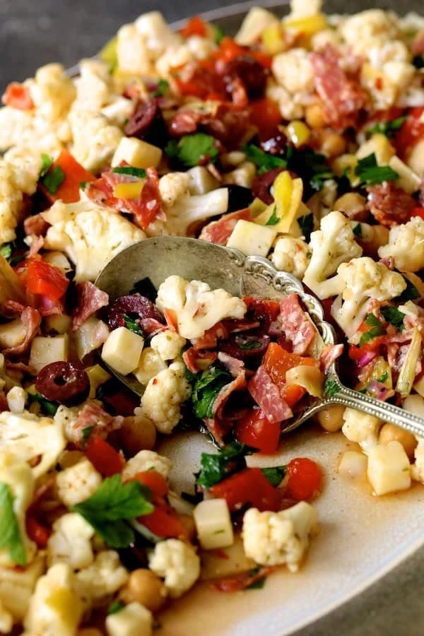 Delicious Cauliflower Antipasto Salad with colorful vegetables and olives.
