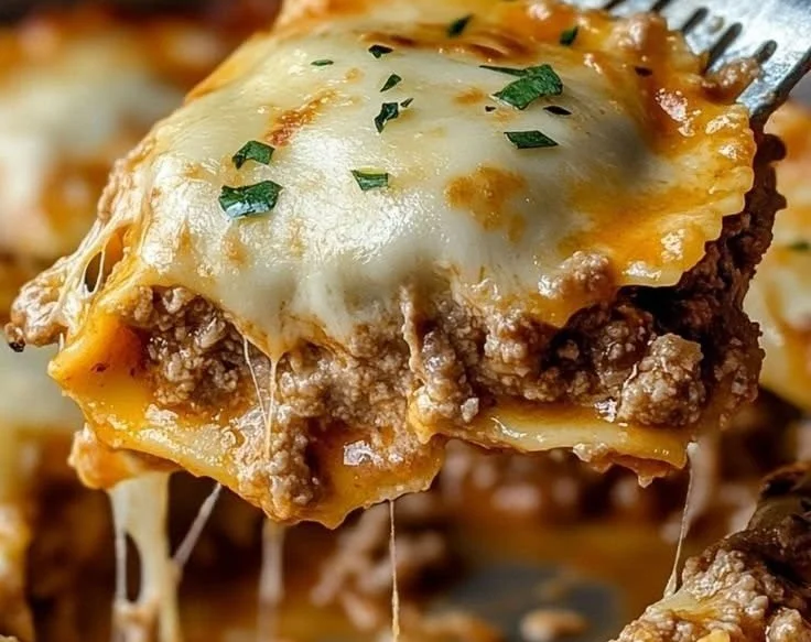 Cheesy ravioli pasta bake topped with melted cheese in a baking dish