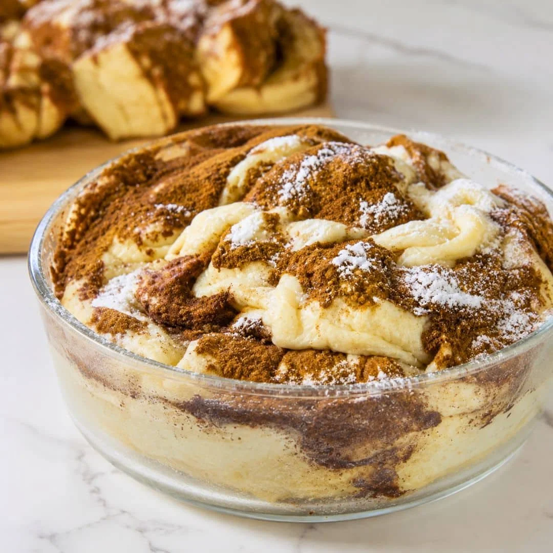 Cinnamon swirl protein cake slice on a plate, topped with icing.