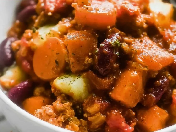 Bowl of easy apple sage turkey chili garnished with fresh herbs