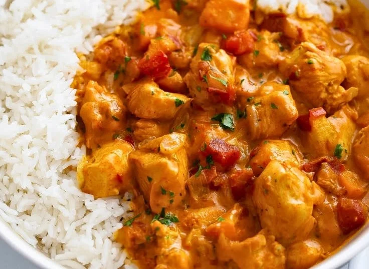 Bowl of easy pumpkin chicken curry garnished with herbs