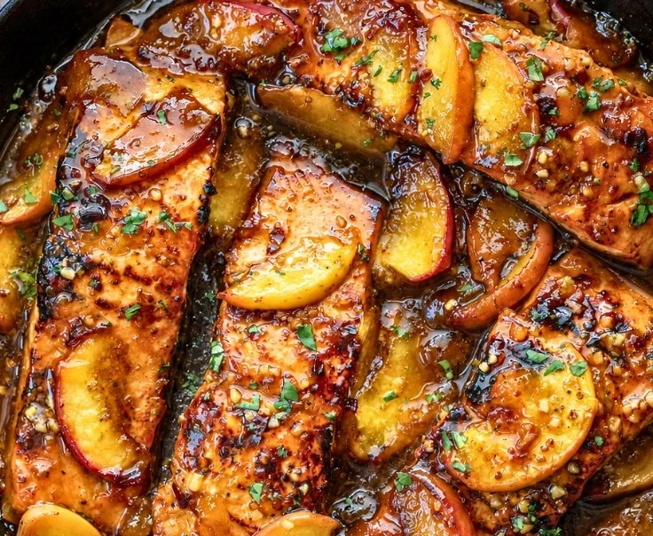Deliciously grilled Bourbon Peach Salmon served with fresh herbs and peaches