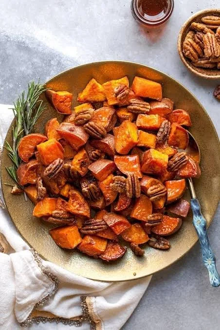 Delicious maple roasted sweet potatoes topped with pecans, perfect side dish
