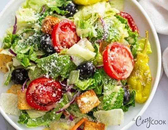 Fresh Olive Garden Salad with greens, olives, and salad dressing