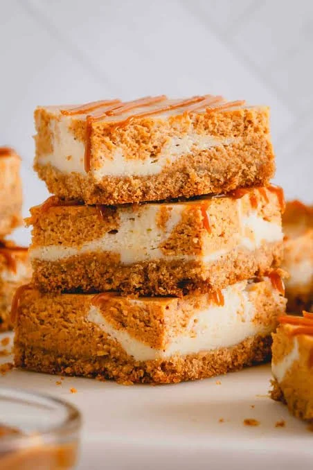 Delicious pumpkin cheesecake bars with graham cracker crust served on a platter