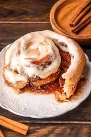 Freshly baked pumpkin cinnamon rolls topped with cream cheese frosting